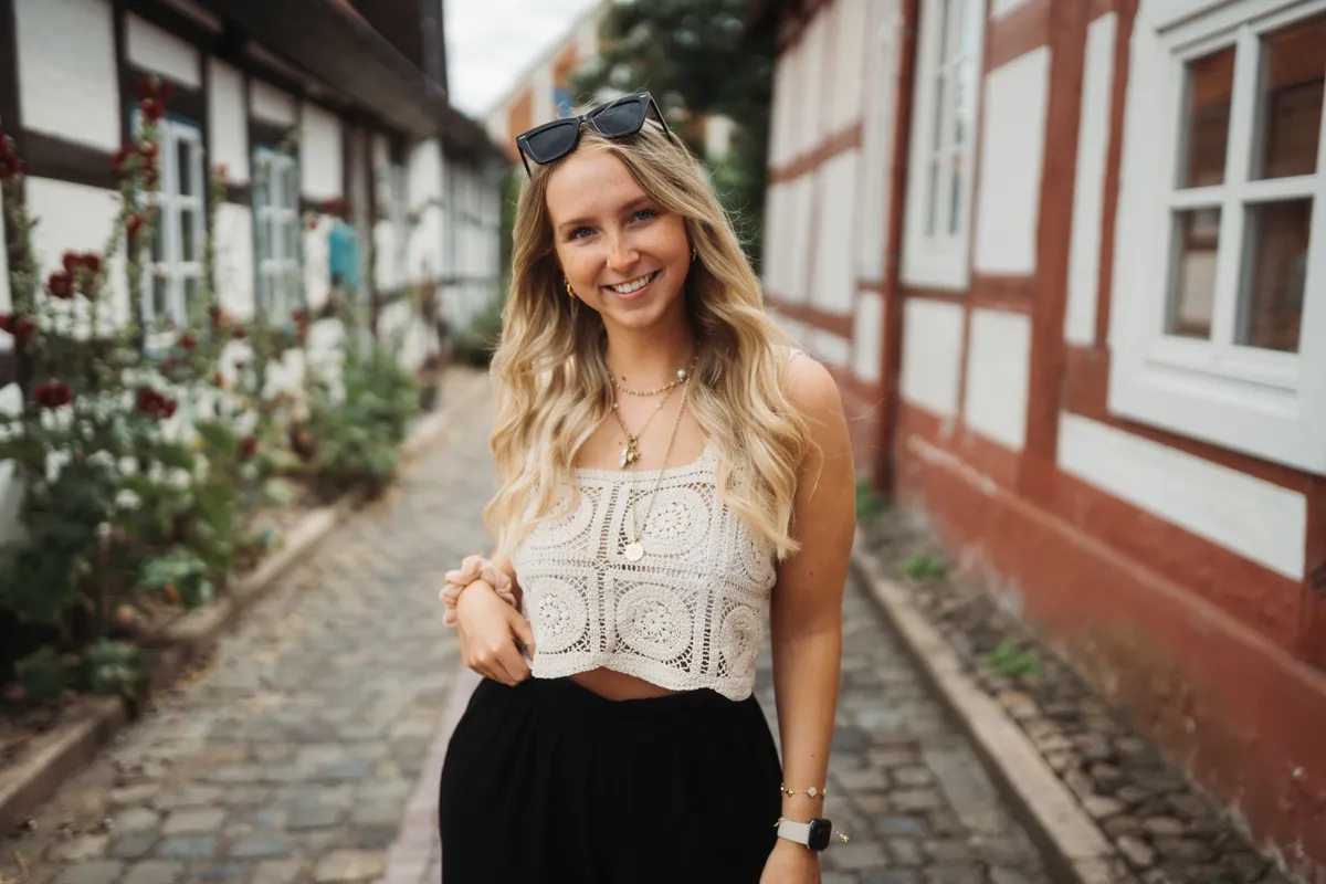 Portraitaufnahme einer jungen Frau vor einer Fachwerkstraße